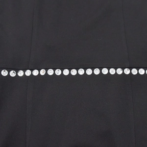 Macro shot of sparkling rhinestones on premium black knit fabric of the mini dress
