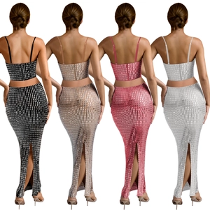 Rear view of women's sparkly two-piece set featuring back zippers and high slit skirts