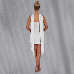 Détail d'une robe blanche à paillettes avec des capes d'épaules longues et un zip au dos