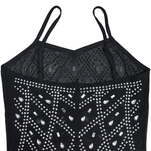 Close-up of black mesh dress featuring intricate silver rhinestones in geometric patterns