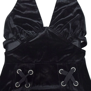 Détail de robe en velours noir avec licou, découpes latérales et œillets métalliques lacés