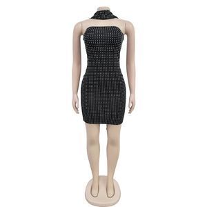Détail de la robe de soirée noire moulante à pois blancs avec tour de cou assorti