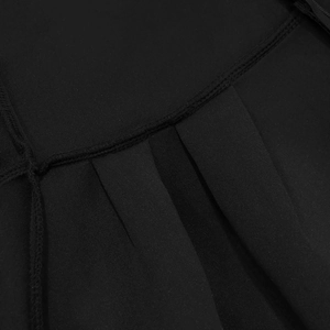 Detailed macro view of the pleated black fabric and high-quality stitching on the dress