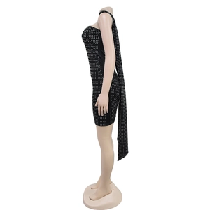 Détail d'une robe noire ajustée avec strass et longue écharpe pour tenue de soirée