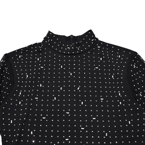 Close-up of black high-neck top with sparkling silver rhinestones and mesh sleeves