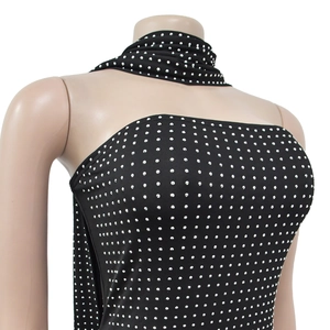 Détail d'une robe noire cintrée avec strass argentés et col licou drapé élégant
