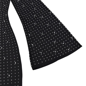 Detailed macro shot of sparkling silver rhinestones on slim fit long sleeve black dress fabric