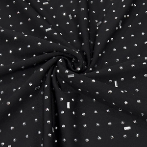 Detail of black elastic knit dress with geometric silver rhinestones and ruffled texture