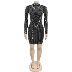 Close-up of black bodycon dress featuring intricate pearl and rhinestone geometric patterns