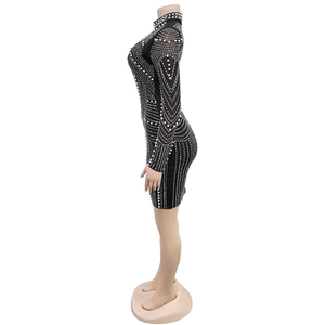 Close-up of black bodycon dress with intricate white pearl embellishments and geometric pattern
