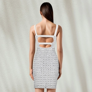 Dettaglio della schiena scoperta con spalline cut-out e strass argentati sull'abito bianco