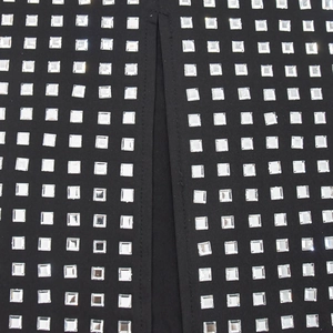 Vue détaillée du tissu en maille noire avec motif d'échiquier en strass carrés