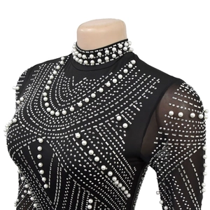 Detailed view of silver rhinestones and white pearls on black mesh long-sleeve dress