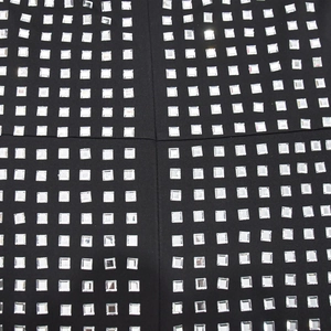 Gros plan de strass carrés argentés brillants sur tissu de robe en maille noire