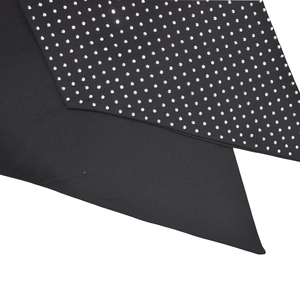 Détail de tissu noir avec strass argentés sur une robe de soirée moulante