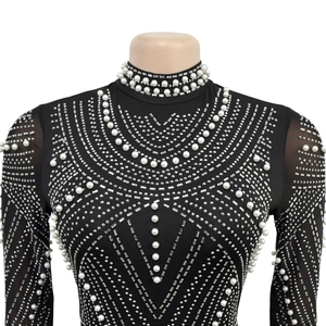 Detailed view of black mesh top with geometric white pearl and silver rhinestone patterns