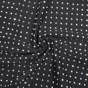 Gros plan sur un tissu extensible noir orné d'un motif en spirale de strass étincelants