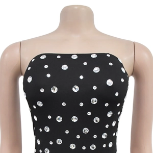 Détail d'une mini robe bustier noire avec strass brillants sur tissu élastique