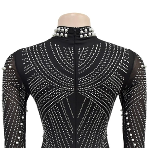 Detail of black slim dress with white pearls on neckline and silver rhinestone patterns