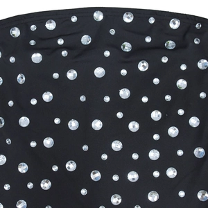 Gros plan sur une robe moulante noire ornée de strass brillants et de coutures précises