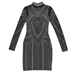 Detail of black slim-fit dress featuring intricate pearl and rhinestone patterns