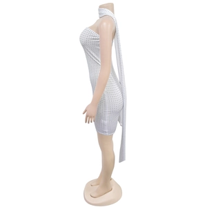 Détail d'une mini robe blanche moulante avec strass argentés et long ruban de cou