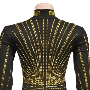 Detailed back view of a black high neck dress featuring golden rhinestone starburst patterns