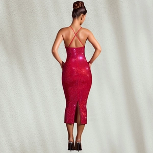 Détail d'une robe rouge à paillettes avec dos nu à brides croisées et fente élégante