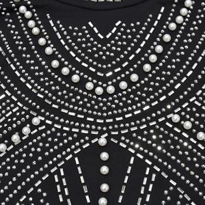 Close-up of intricate rhinestone and pearl embellishments on a black slim-fit dress