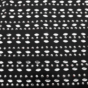 Macro detail of sparkling silver rhinestones on elegant black slim fit dress fabric