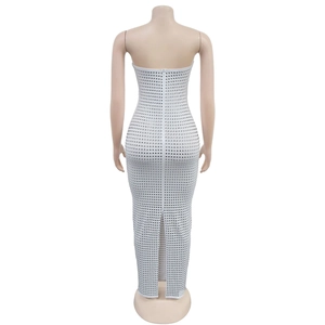 Détail d'une robe moulante blanche à épaules dénudées avec strass brillants et fente arrière