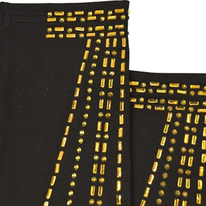 Detailed view of luxury gold rhinestones on black knit fabric with geometric patterns