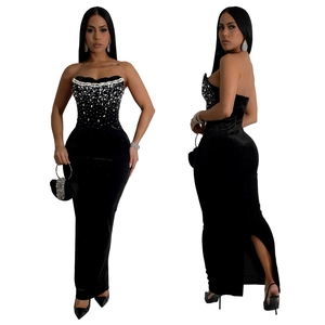 Détail de la robe de soirée en velours noir à épaules dénudées avec strass argentés et fente