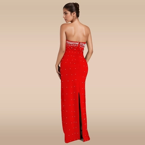 Détail de robe de soirée rouge bustier avec perles blanches et fente élégante au dos