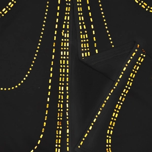 Detail of elegant black fabric featuring vertical rows of golden rhinestones and studs
