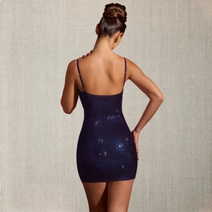 Détail d'une mini robe à paillettes violet foncé avec dos nu et tissu scintillant