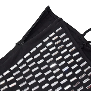 Detailed macro view of black fabric with sparkling rectangular rhinestones and hidden zipper
