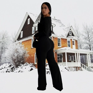 Side view of women's black long sleeve bodycon jumpsuit with wide leg silhouette