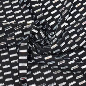 Macro detail of sparkling rectangular rhinestones on black sexy bodycon dress fabric