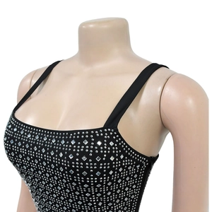 Dettaglio dell'abito aderente nero con intricati motivi geometrici in strass argentati