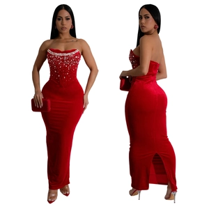 Détail de la robe en velours rouge à épaules dénudées avec perles et fente latérale