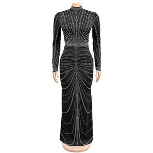 Detailed view of black slim-fit dress with geometric rhinestone patterns and slit