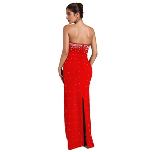 Détail d'une robe de soirée rouge bustier avec des ornements en perles blanches et fente au dos