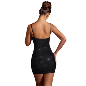 Gros plan sur le tissu en résille à paillettes noires et la coupe dos nu de cette robe