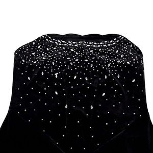 Détail d'une robe en velours noir avec des strass argentés à motif rayonnant