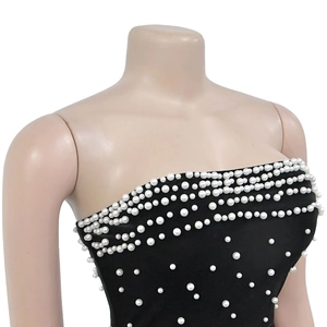 Détail de perles blanches élégantes sur une robe bustier noire avec dégradé de perles chic
