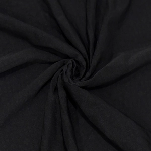 Dettaglio macro del tessuto a maglia nera con strass scintillanti per abiti eleganti