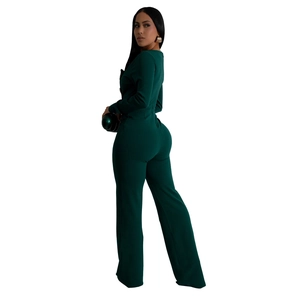 Detail of slim fit long sleeve dark green jumpsuit with wide leg pants and ball clutch