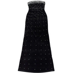 Détail d'une robe bustier en velours noir ornée de perles blanches en dégradé