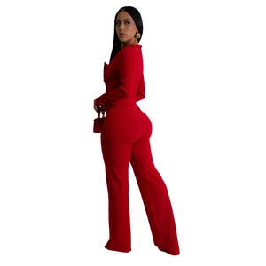Detail of elegant red long sleeve slim jumpsuit with premium textured fabric and gold earrings